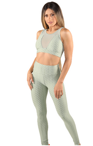 Girl wearing Shape Up Athletics popcorn textured and ruched leggings with matching sports bra in green