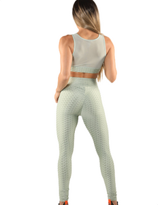 Girl wearing Shape Up Athletics popcorn textured and ruched leggings with matching sports bra in green